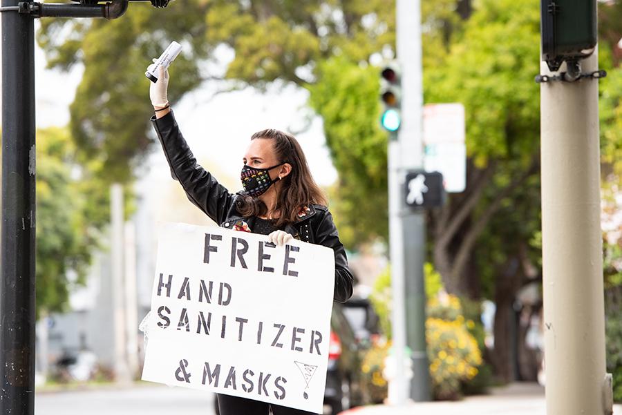 UCSF Postdoc Larissa Maier handing out free bottles of hand sanitizer and masks