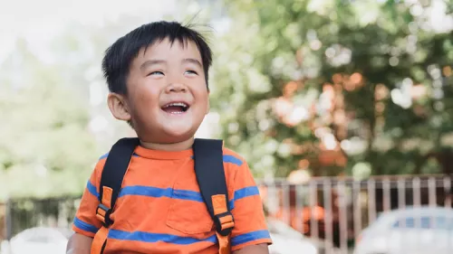School aged child giggles in the sun