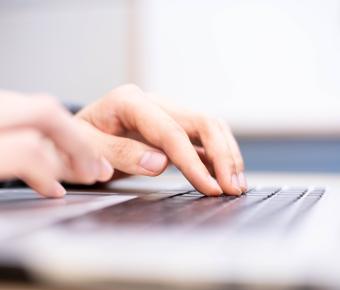 Hands typing on a keyboard