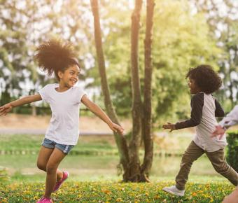 children playing a game of tag in a sunny forest