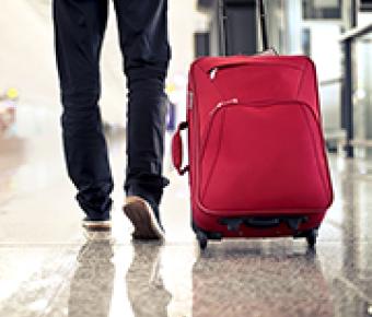 Person wheeling red luggage